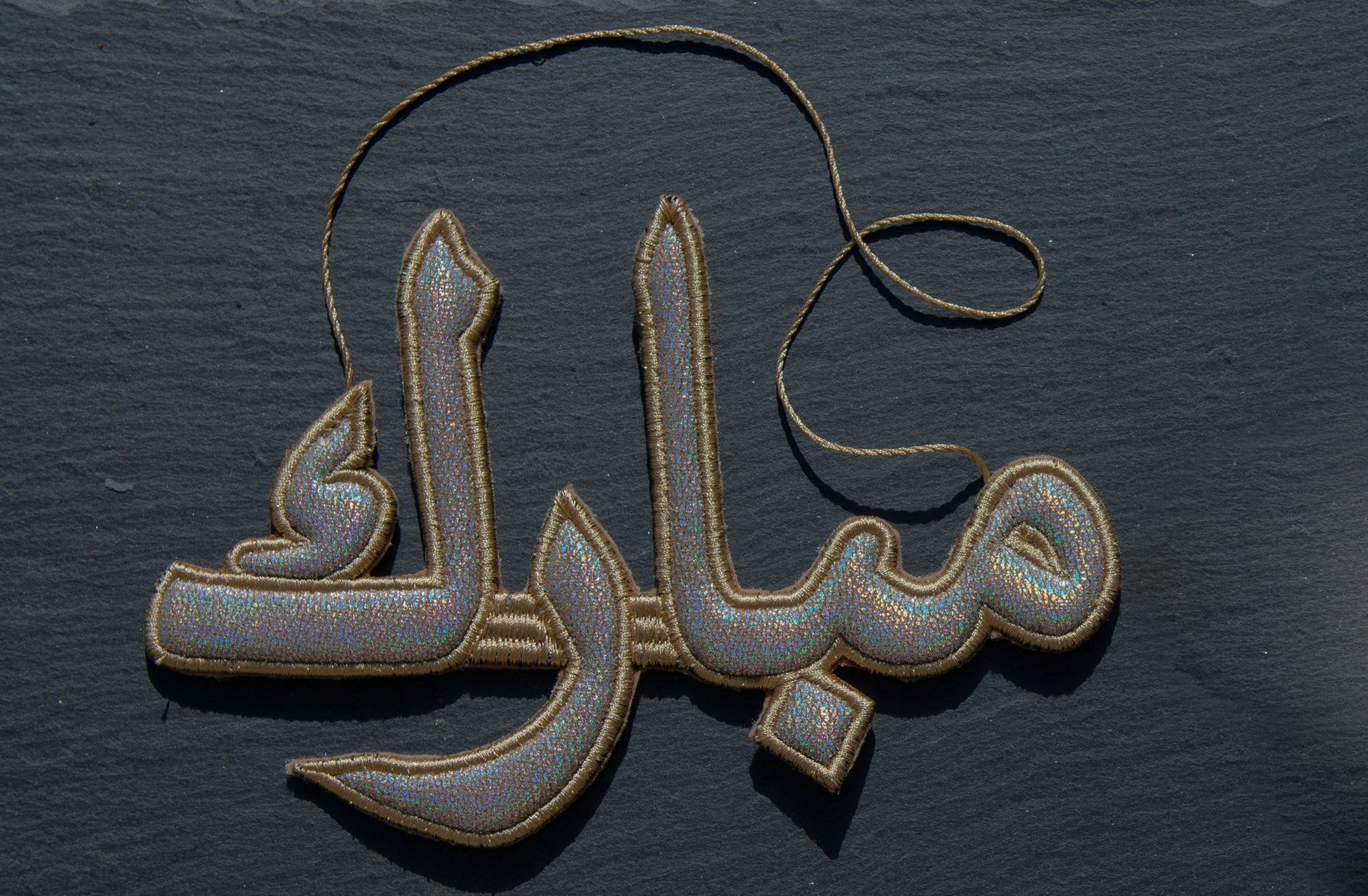 "مبارك" Mubarak Arabic Calligraphy Silver Embroidery Ornament On dark Background