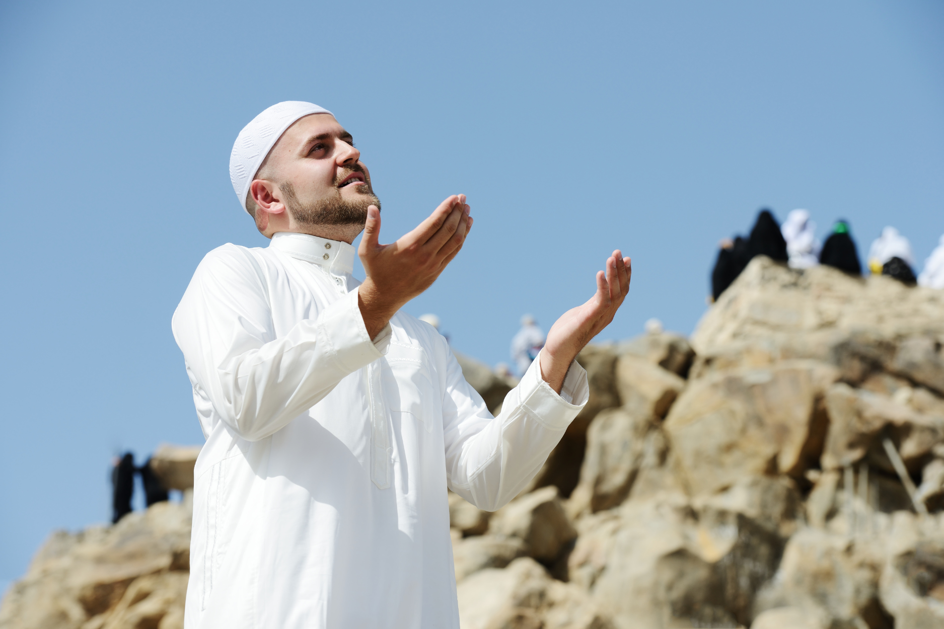 Muslim man supplicating at mount Arafat