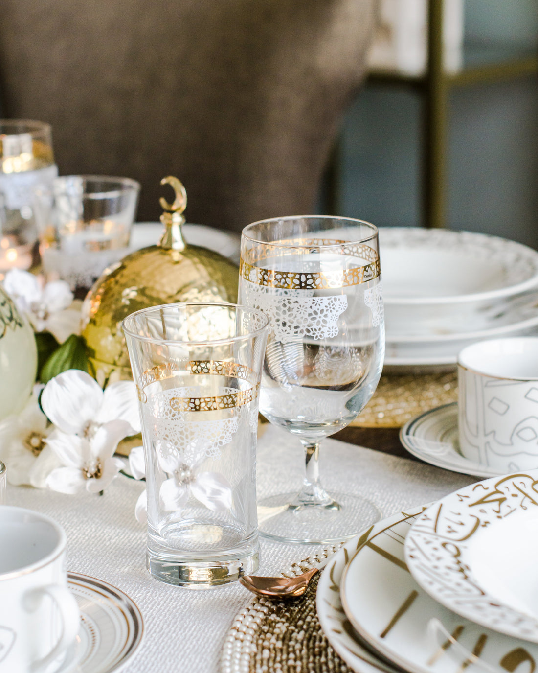 Lilac drinkware with golden and white design  placed on dining table